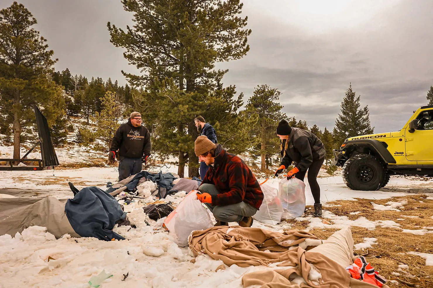 A group of workers from Backbone Adventures clean up an ATV trail on a snowy day.